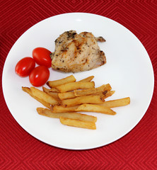 Chicken combo dish with fried potatoes and tomatoes
