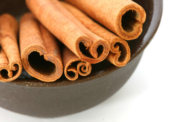 Whole cinnamon sticks in brown bowl