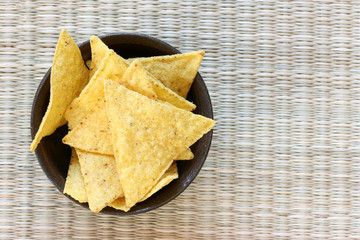 Mexican tortilla chips in brown bowl on white background