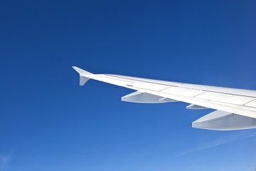 wing of aircraft in clear blue sky - travel concept