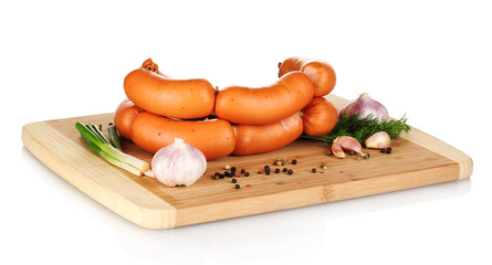 tasty sausages on wooden board and spices isolation on white