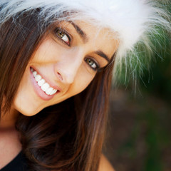 Fototapeta premium Portrait of a sexy young female smiling in a park and looking at