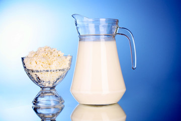 Cottage cheese  in bowl with milk on blue background