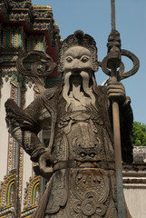 Giant stone guardians in Thai temple .