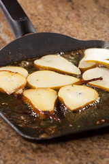 Pear slices pan fried in sugar, in pan