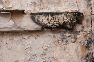 Charred wood on a plaster wall in a derelict building