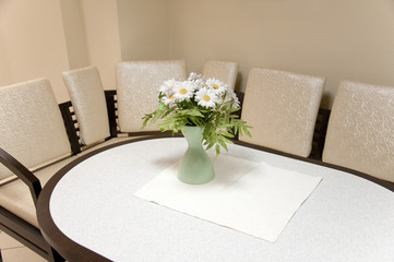 A bouquet of beautiful white daisies on the table in the room