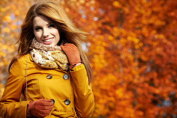 Portrait of an autumn woman lying over leaves and smiling