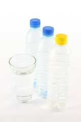 Drinking water in bottle and glass on white table.