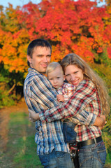 Fototapeta premium Young family in autumn forest