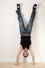 A joyful young man doing a handstand