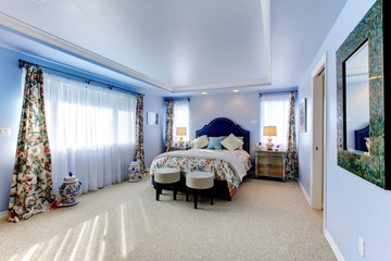 Blue large luxury bedroom with three windows