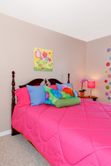 Girls pink bed with colorful pillows