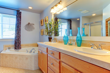 Blue bathroom with large tub and double sink cabinet