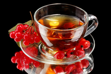 Glass viburnum black tea in cup isolated on black