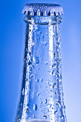 Obraz na płótnie Canvas blue transparent soda bottle with cap and water drops