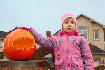 little girl and pumpkin of Halloween building house