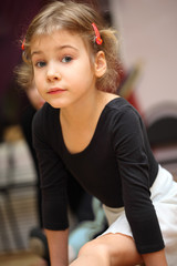 little girl in ballet class sits on string on floor and looks © Pavel Losevsky