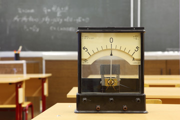Educational galvanometer with not real number 555 on yellow desk