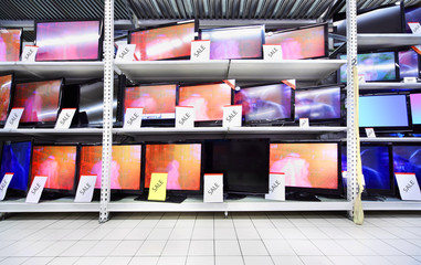 Plasma TVs with big diagonal stand on shelves in large store