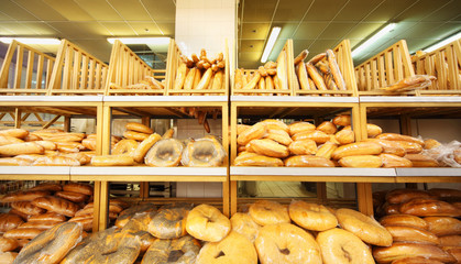 lots of fresh crisp loaves of bread on shelves in store