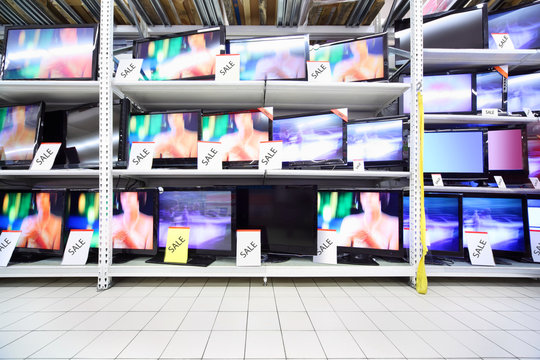 Plasma TVs with big diagonal stand on shelves in large shop