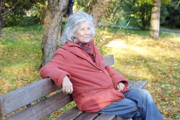 Lächelnde Seniorin auf Parkbank