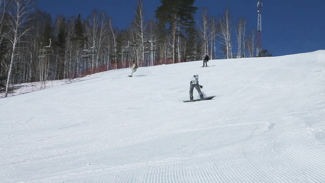 Group of four snowboarders taking a tricky ride down the hill