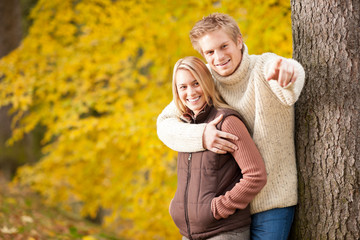 Autumn romantic couple smiling together in park