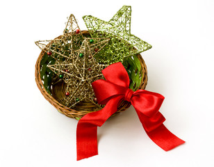 Christmas decorations: stars and red bow in a wicker vase