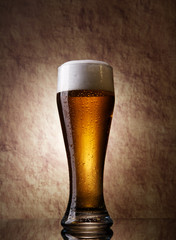 Beer into glass on a old stone