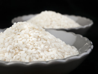 Arroz en cuenco sobre fondo negro. Vista de frente