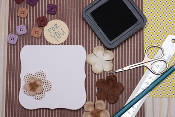 hand made scrapbooking post card and tools lying on a table.