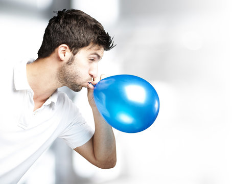 man blowing balloon