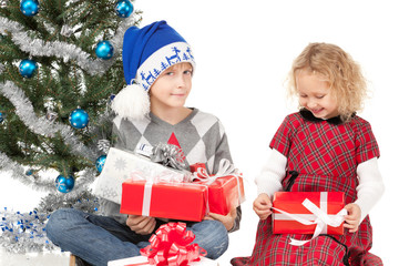Two kids unwrapping their christmas presents