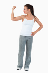 Fototapeta premium Young woman showing her biceps