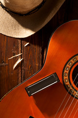 Harmonica on Guitar with Cowboy Hat on Wood