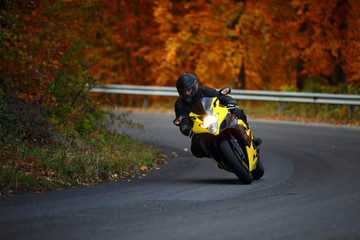 Naklejka premium man riding with speedbike in autumn