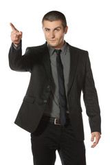 Young business man in suit pointing at copy space