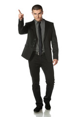 Full length of young business man in suit pointing