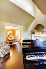 Cream yellow living room with grand piano and dining