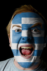 Face of crazy angry man painted in colors of greece flag