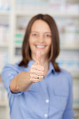 frau in der apotheke zeigt daumen hoch