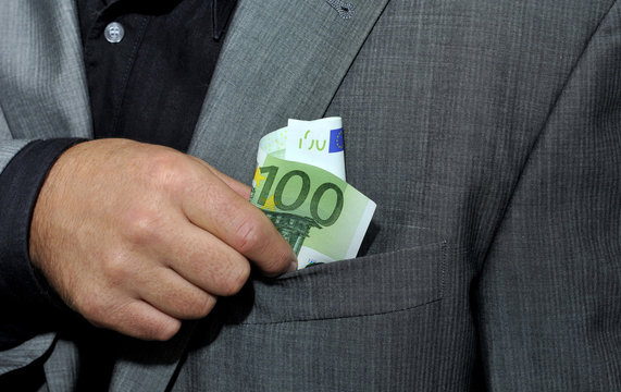 Hand steckt 100 Euro in Jacket