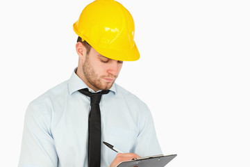 Young lead worker taking notes on his clipboard