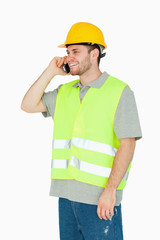 Smiling young construction worker on the cellphone