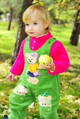 Маленькая девочка на зеленой траве осенью