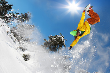 Snowboarder jumping against blue sky