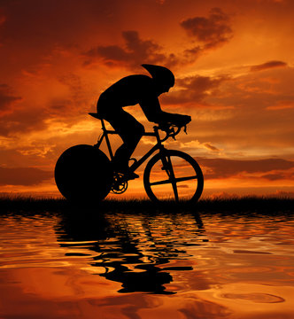 Road biker silhouette in sunrise