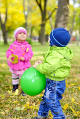Двое малышей играют воздушными шариками
